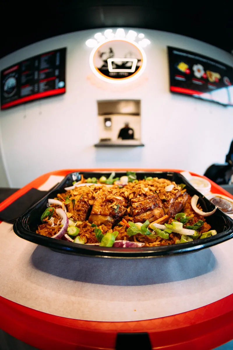 Een vol bord nasi met kip, vooraan in de zaak van Oscar's.